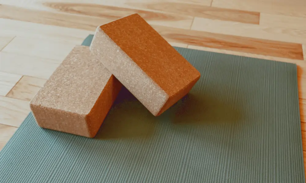 Bild von Yogablock aus Kork auf grüner Yogamatte auf Holzboden in Yogastudio