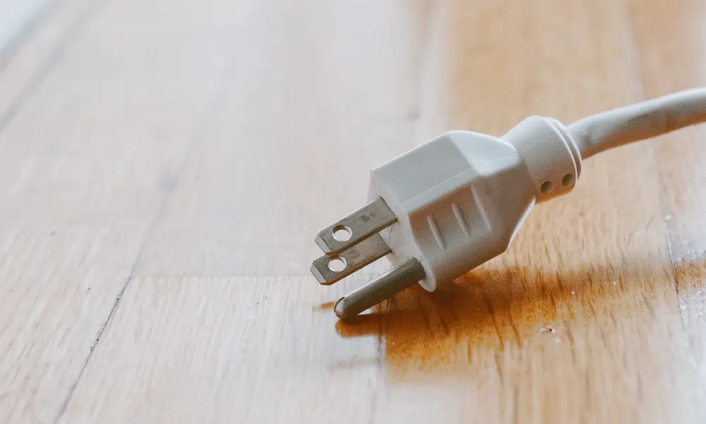 Reiseadapter Schweiz UK Stromkabel auf Holzboden