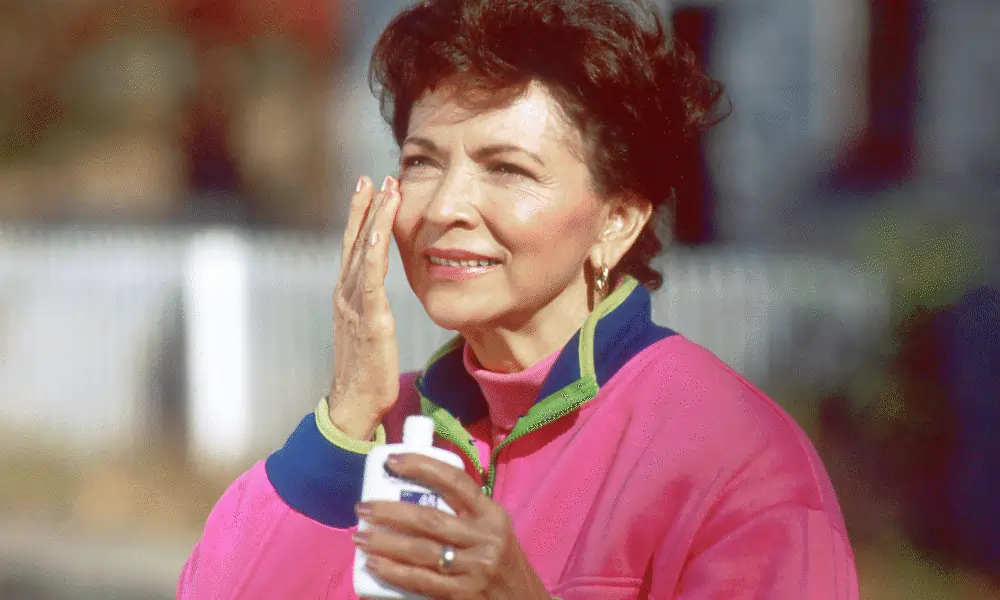 Bild von Frau trägt Sonnencreme auf Gesicht auf